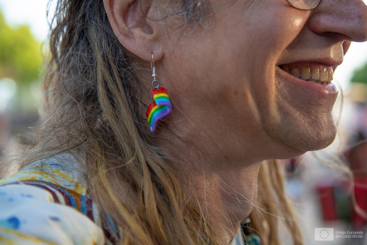 Picture of lady wearing an earring with a rainbow flag