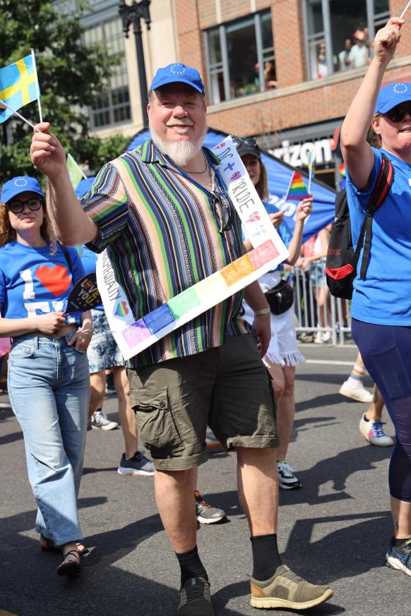 A bearded man waves a Swedish flag.