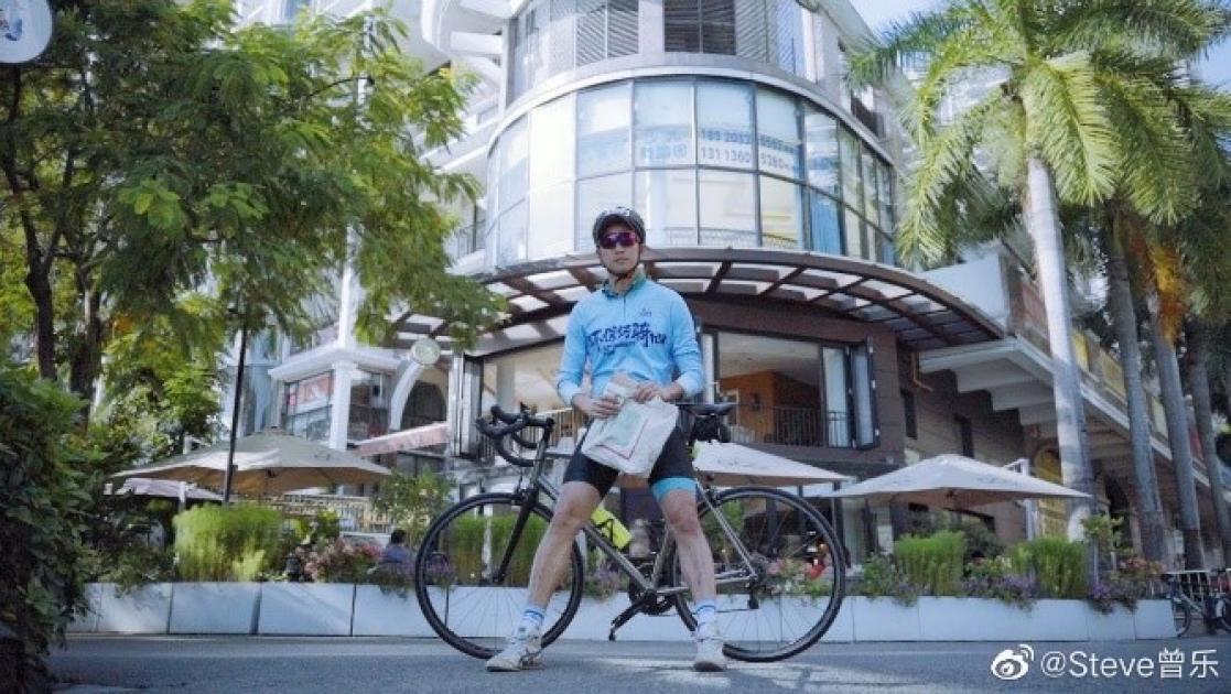 Man sitting on a bicycle in front of a building