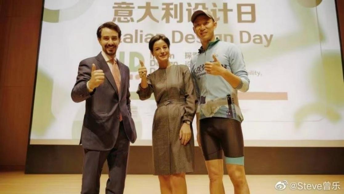 Three people posing with their thumbs up on a stage.