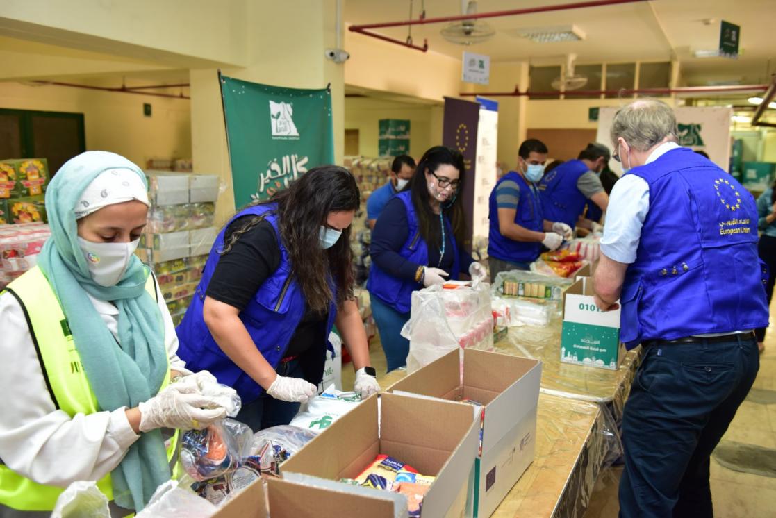 People filling boxes with food