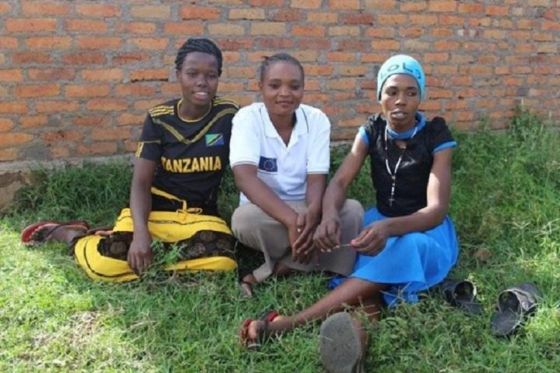 Three children sitting on the grass