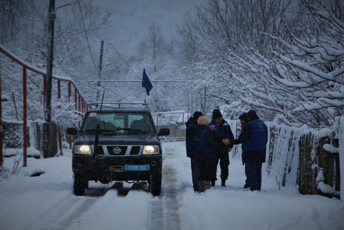 People next to a car in the snow