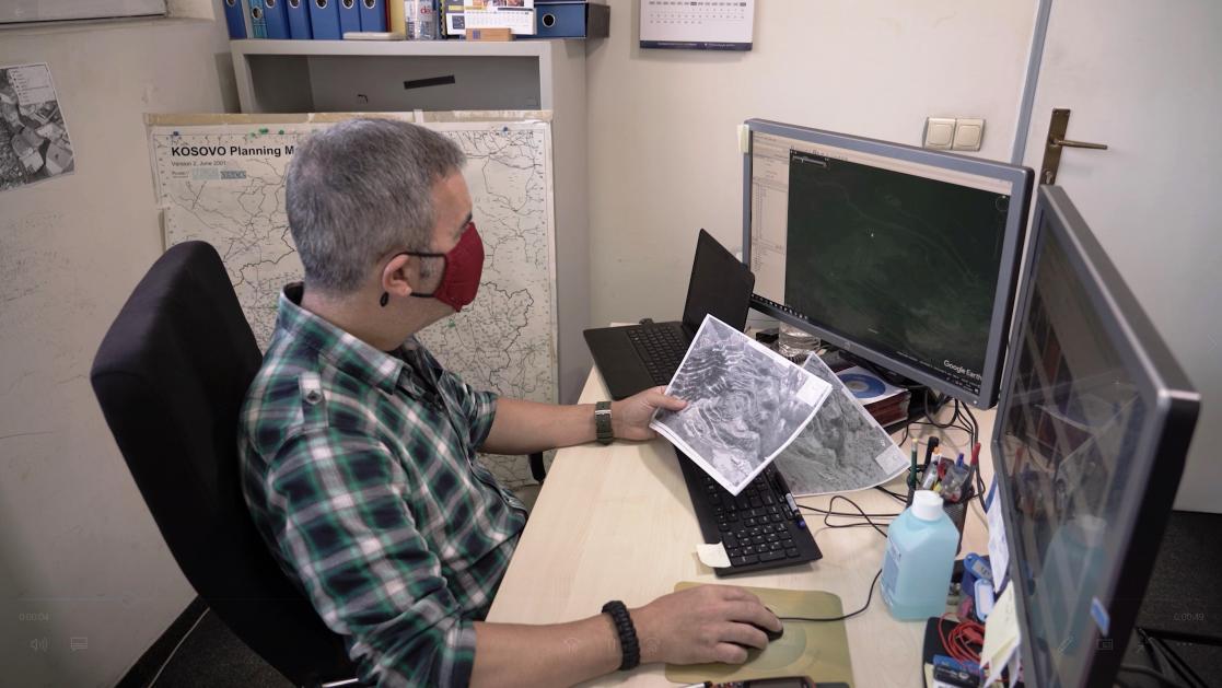 Man reviewing maps on paper and computer