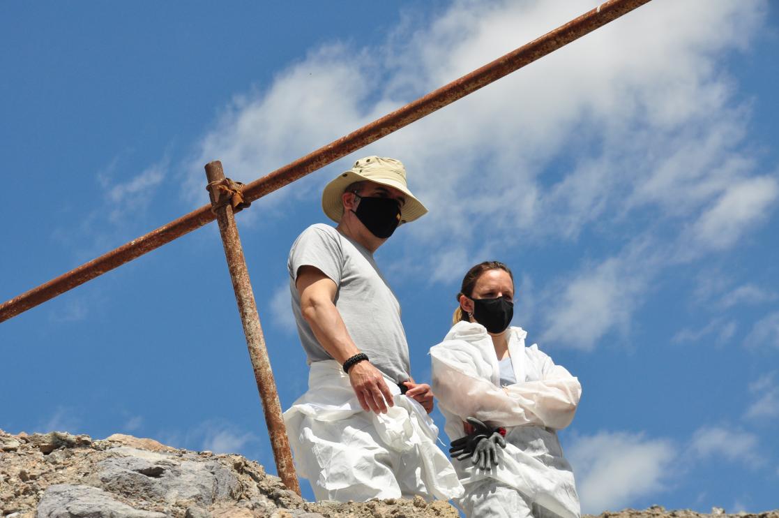 Two people dressed in overalls and sanitary masks