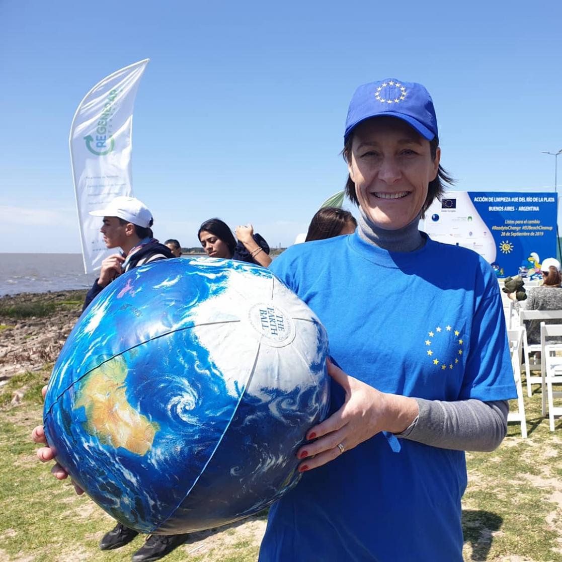 Woman posing with an inflatable ball in the shape of the Earth