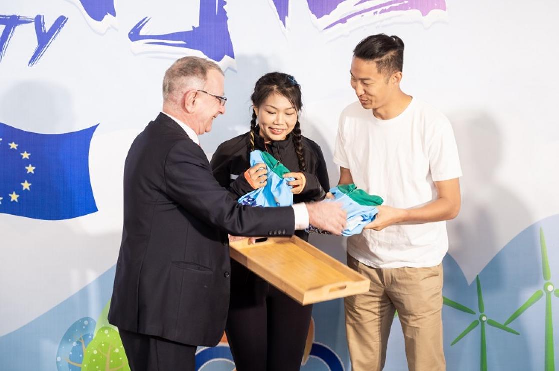 Man giving two T-shirts to two young