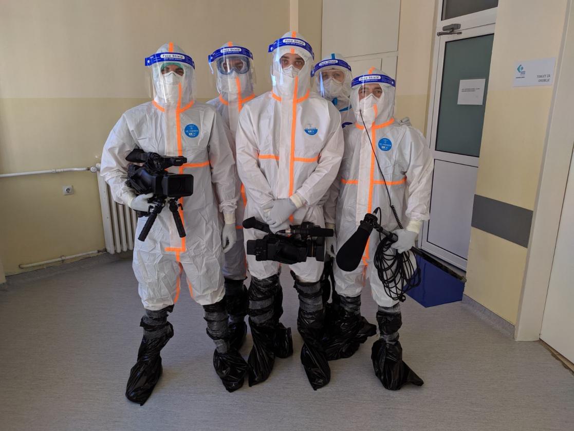 Group of men with cameras wearing sanity protection clothes