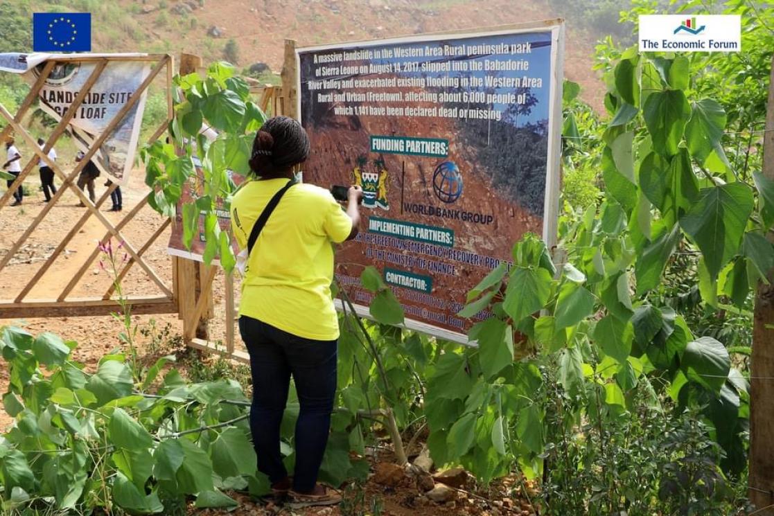 Woman taking a photo to a poster