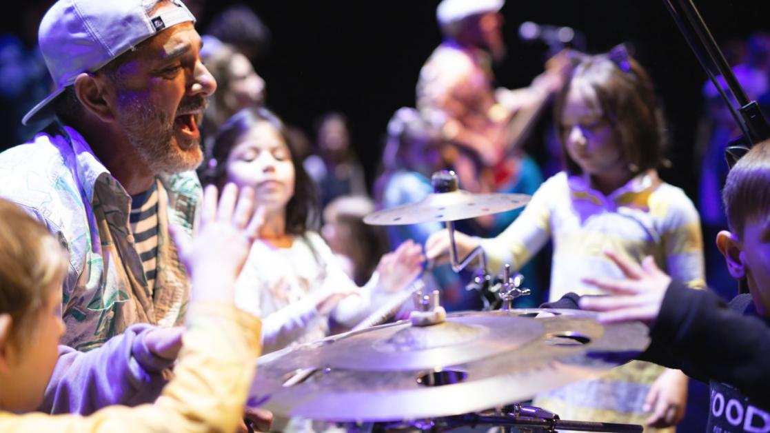 Musical performer interacts with children