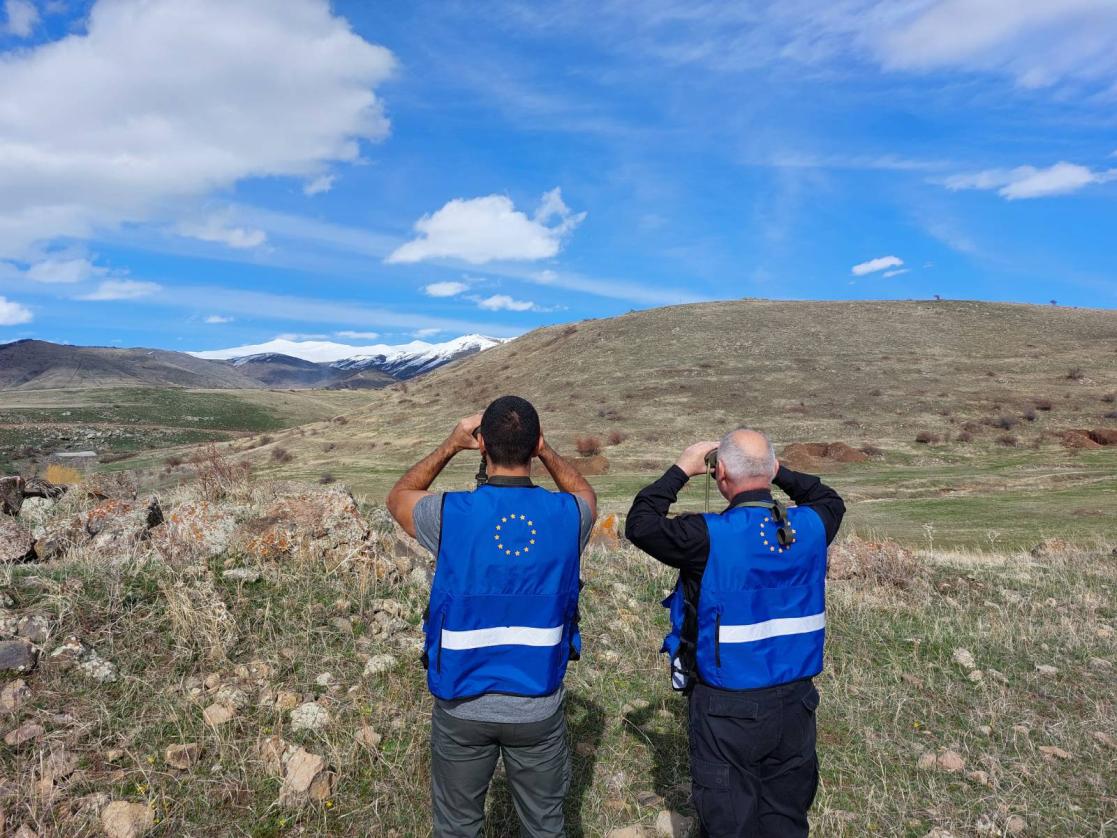 Two men looking through a pair of binoculars