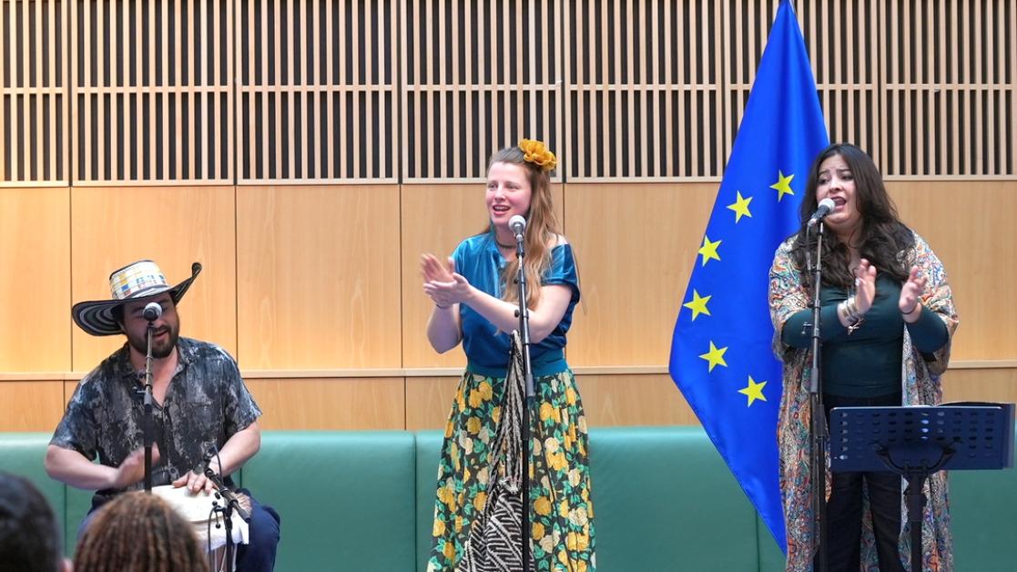 Three performers singing on stage.