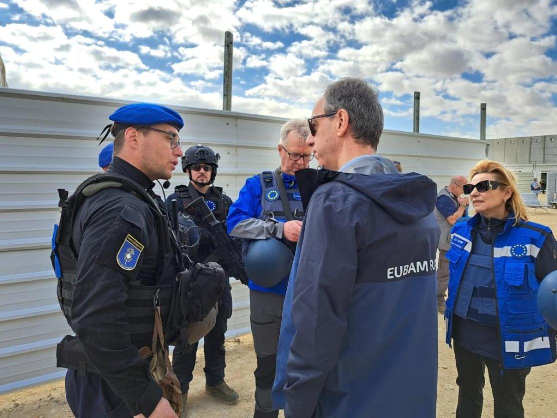 Civilians and EU operational personnel in discussion at checkpoint.