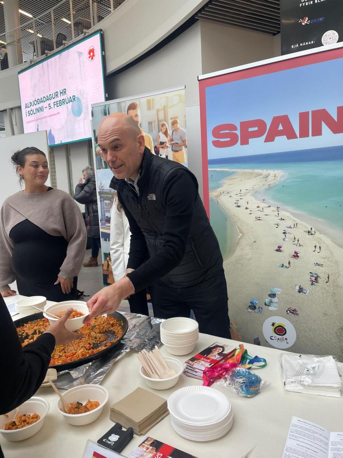 Spanish embassador handing out plates of paella