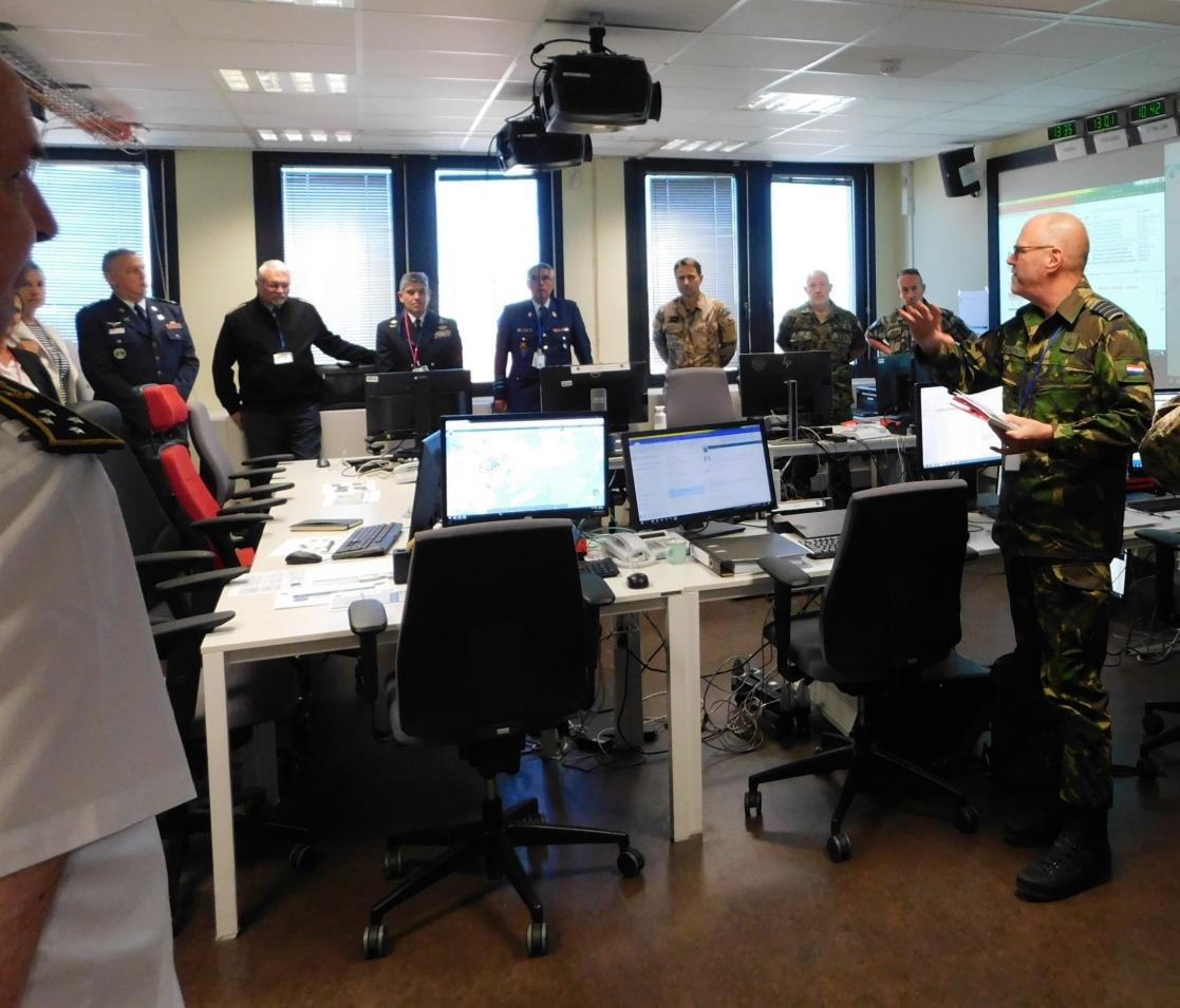 military staff standing in an office with computers on desks