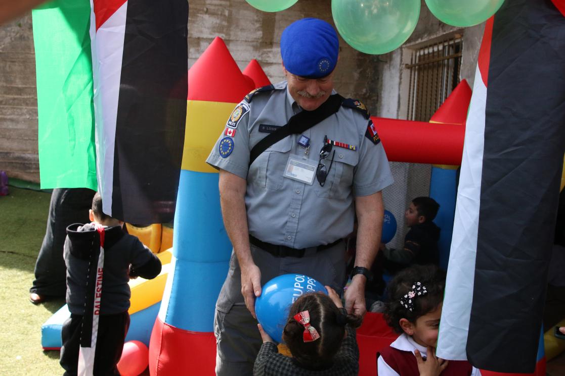 Men in military uniform giving a balloon to a kid