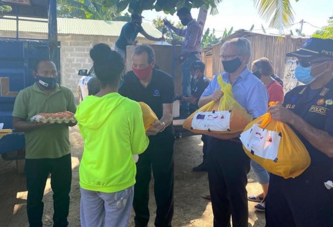 Group of people giving yellow bags to a woman