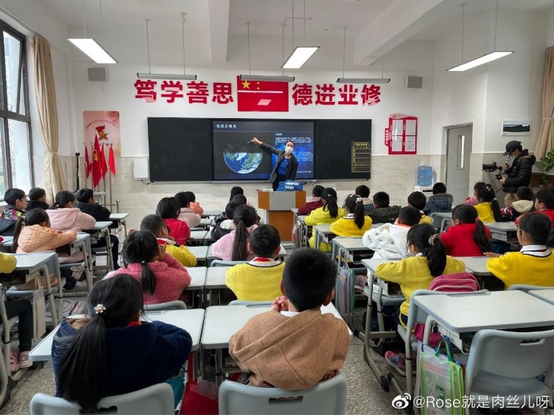 Children posing with their backs to the camera during a lesson in a school