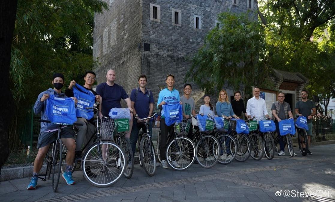 Group of people posing with bikes and holding t-shirts