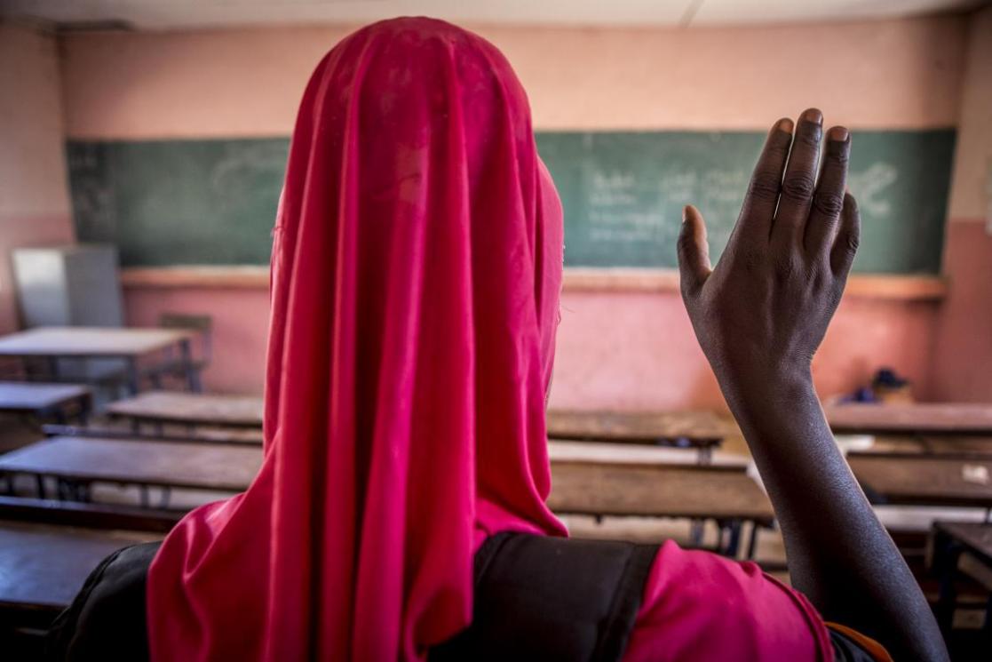 Woman, back to back, hand raised