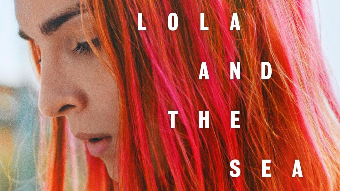 A young woman with red hair looks down with the words "Lola and the Sea" over top