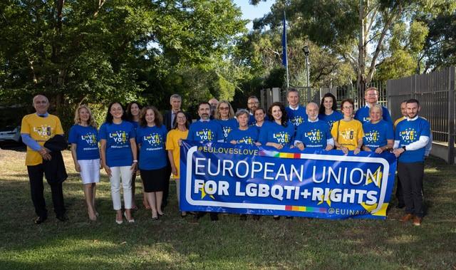 group of people in LGBTIQ+ tshirts with banner