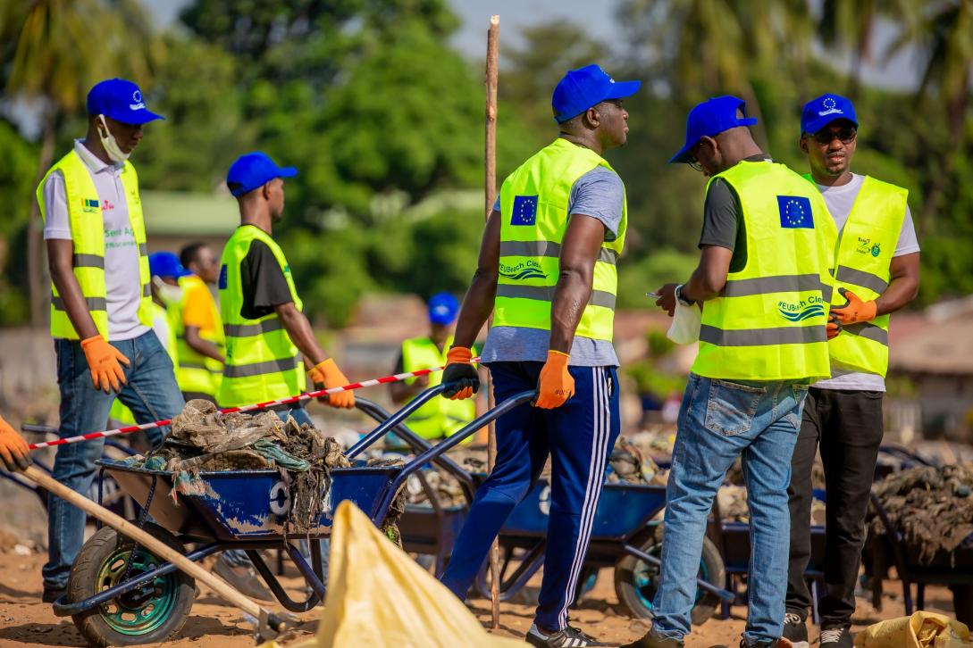 Des volontaires poussant des brouettes remplies de déchets