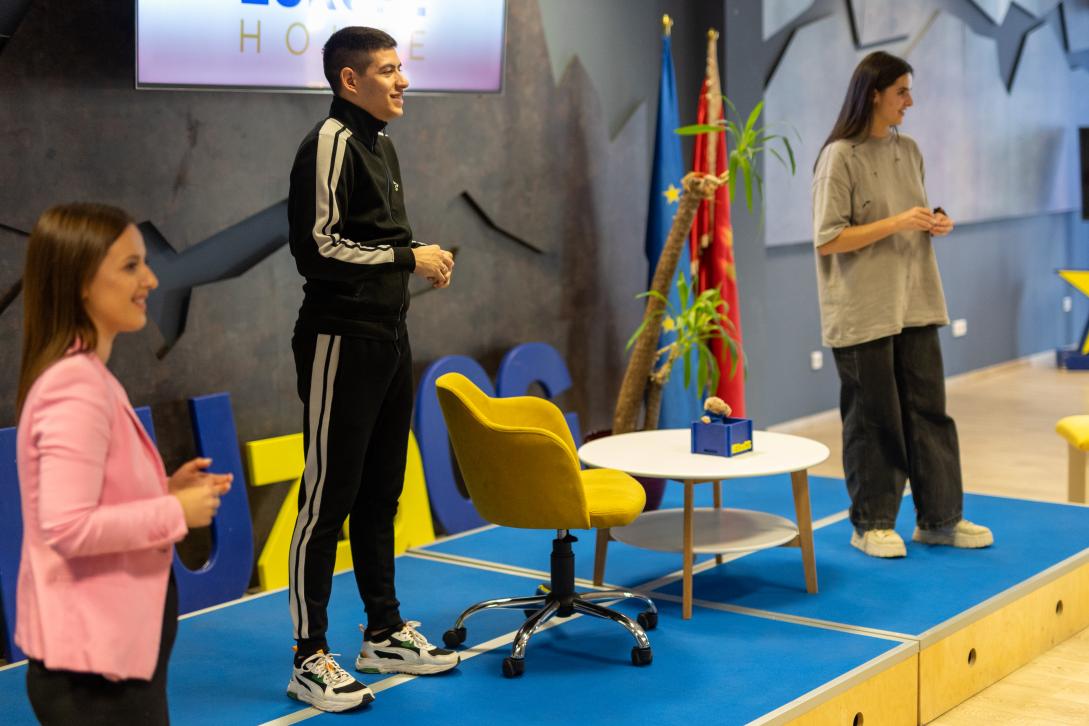 Two actors and a moderator standing on stage during the event in Europe House