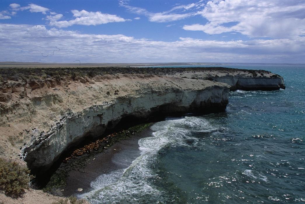 A coastal landscape with the sea breaking on the rocks.