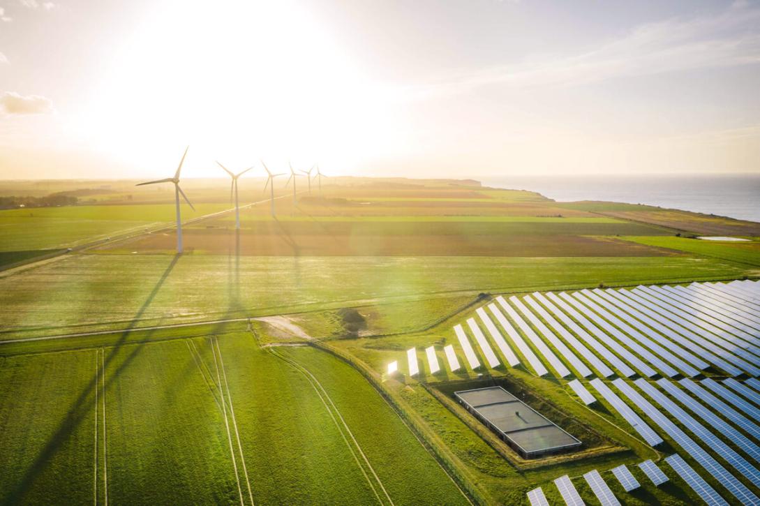 Wind turbines, green fields, ocean and solar panels for Green Transition concept. 