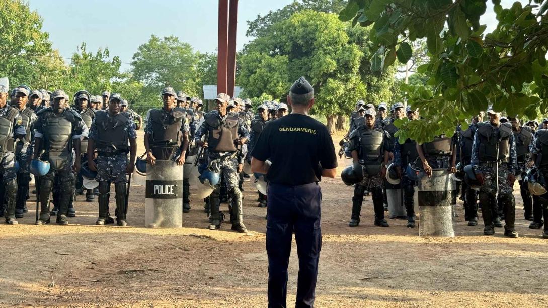 A troop of police officers stand to attention facing the camera.