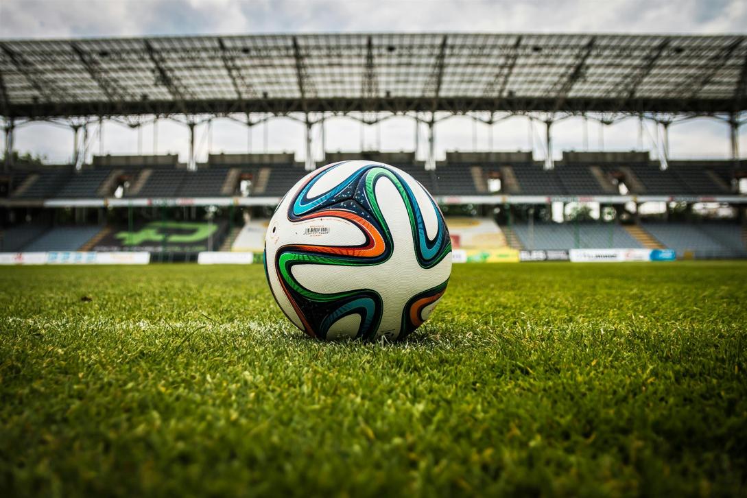 Close up of the football ball laying on the grass of the football field.