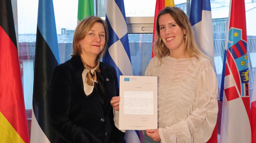 picture of a trainee holding a certificate next to the EU Ambassador 