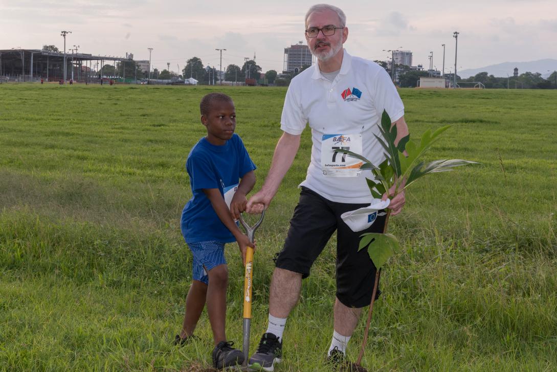 Ambassador Cavendish gets help to plant a tree at the EU 5K Run and Tree Planting event.