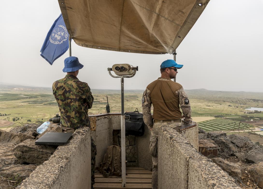 2 UN peacekeepers on a balcony looking at the horizon