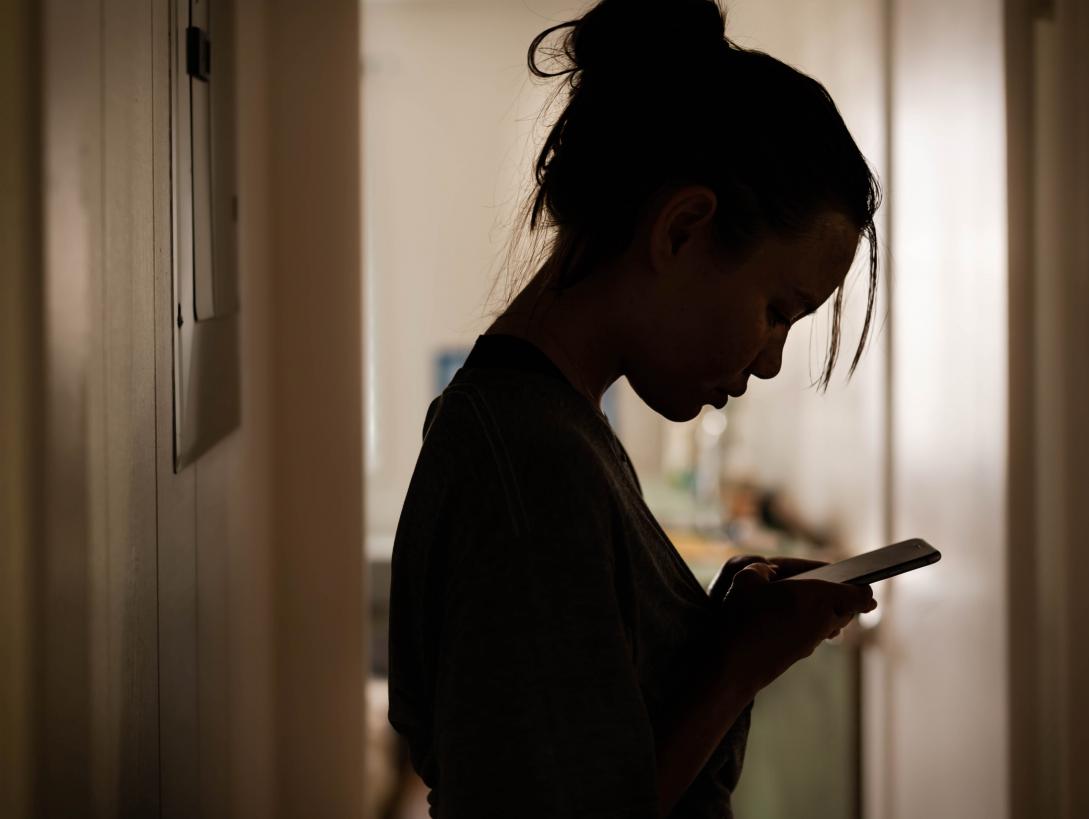 Gloomy girl on phone (iStock)