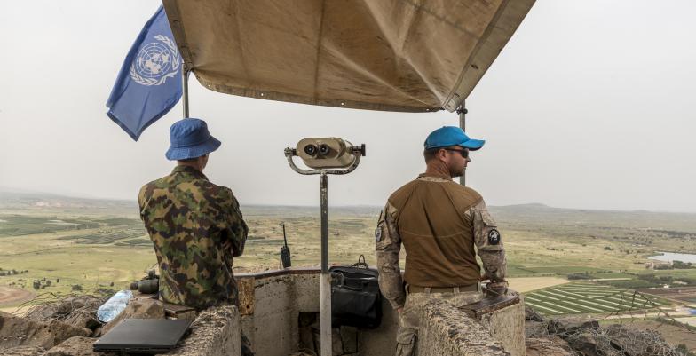 2 UN peacekeepers on a balcony looking at the horizon