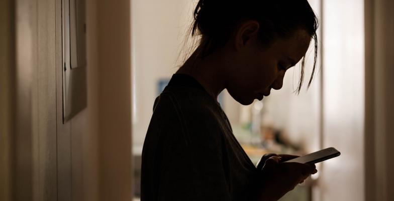 Gloomy girl on phone (iStock)