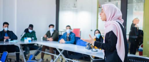 a veiled woman teaching a class